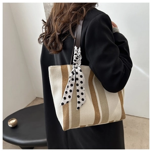 Detailed texture of vertical striped canvas tote bag with decorative polka dot scarf