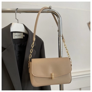 Détail du sac bandoulière en similicuir beige avec boucle dorée et bandoulière chaîne