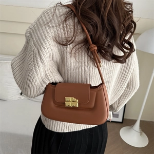 Caramel brown leather shoulder bag with gold geometric buckle and sleek strap