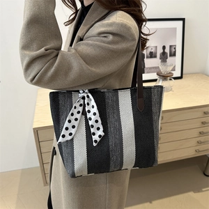 Vertical striped knit tote bag with brown leather handles and polka dot scarf detail
