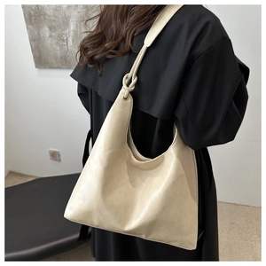 Detail of the knotted shoulder strap on a beige PU leather hobo tote bag for women