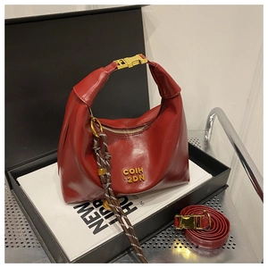 Deep red hobo bag detail with gold logo and black-white braided cord decoration