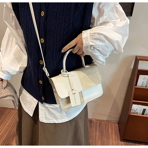 Detail of cream white canvas crossbody bag with top handle and faux leather strap