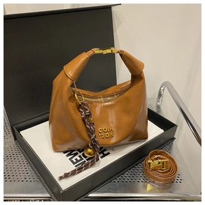 Detail of brown leather dumpling bag with gold buckle, logo print, and adjustable strap