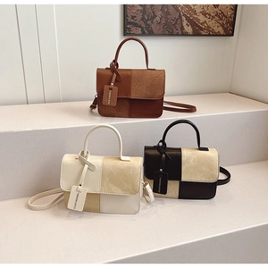 Detail of minimalist leather crossbody bags featuring geometric patchwork and branded tags
