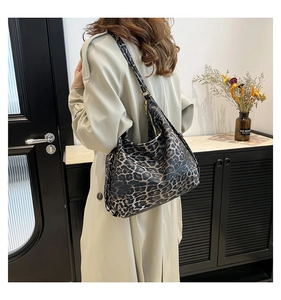 Detail of leopard print canvas tote bag featuring adjustable strap and smooth metal zipper