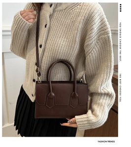 Close-up of a deep brown leather tote bag with elegant stitching and adjustable strap