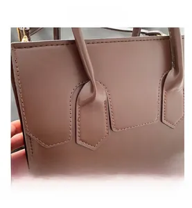 Detailed close-up of brown PU leather handbag featuring geometric shield stitching patterns