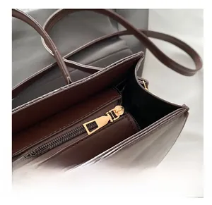 Close-up of smooth metal zipper and internal compartment on dark brown leather handbag