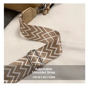 Detail of adjustable woven shoulder strap with beige geometric pattern and silver buckle