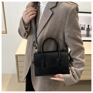 Classic black leather handbag styled with a brown herringbone blazer for a professional look