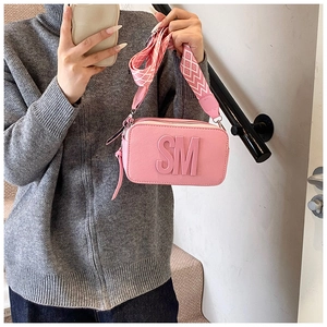 Pink crossbody bag with embossed SM logo and stylish geometric patterned wide strap