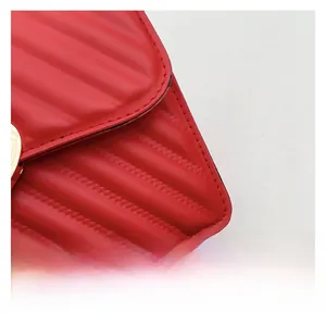 Dettaglio borsa in pelle trapuntata rossa con eleganti cuciture a V e fibbia dorata