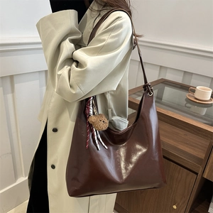 Minimalist deep brown faux leather tote bag with plush bear charm for daily commuting