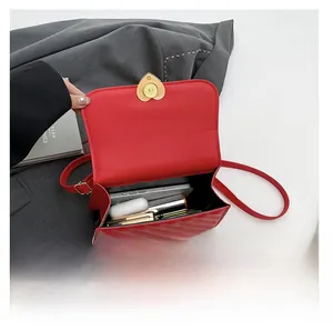 Vista interna della borsa rossa trapuntata con chiusura a cuore e cosmetici