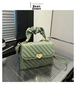 Sage green PU leather handbag with diagonal quilting and golden heart lock detail