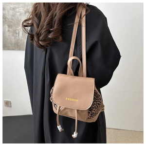 Mini khaki leather backpack with leopard print panels and Fashion print on a model