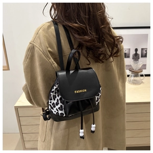 Detail of mini backpack featuring leopard print sides and gold FASHION text lettering