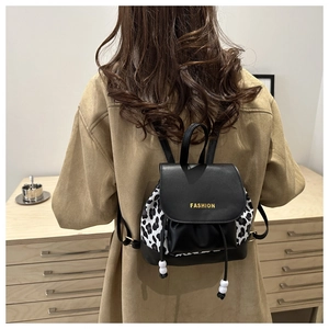 Detail of mini leather backpack with leopard print panels and gold fashion text print