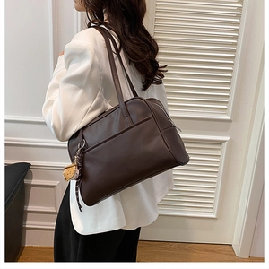Brown leather tote bag featuring a large front pocket and a cute yellow animal charm