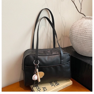 Black matte leather tote bag detail with vintage baseball themed keychain charms