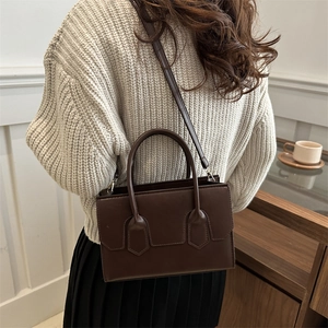 Deep brown faux leather tote bag with top handles and adjustable strap for women