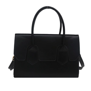 Minimalist black tote bag with flap closure and adjustable strap on white background