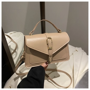 Detail of beige envelope crossbody bag with top handle and adjustable strap close-up