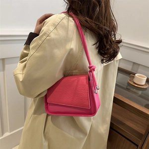 Borsa a tracolla rosa shocking con patta testurizzata su un trench beige chic