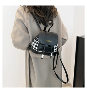 Detail of black leather backpack with houndstooth side panels and drawstring bead accents