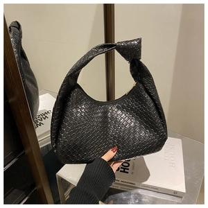 Dettaglio di una borsa hobo nera intrecciata con manico a nodo e cerniera in metallo dorato