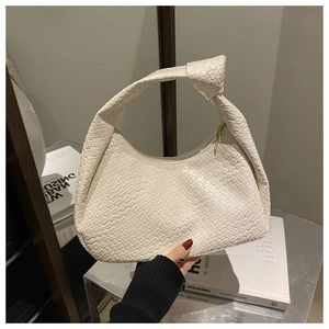 Dettaglio borsa hobo intrecciata bianca con manico a nodo e morbida trama in pelle