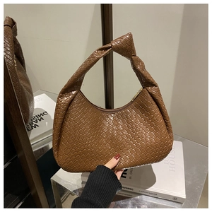 Dettaglio di borsa hobo intrecciata marrone scuro con un caratteristico manico a nodo