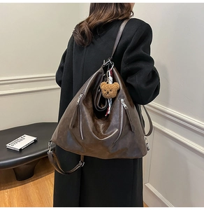Vue détaillée du sac à dos vintage marron avec fermetures éclair et porte-clé ours