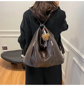 Détail d'un sac à dos vintage en similicuir marron avec breloque ours sur mannequin