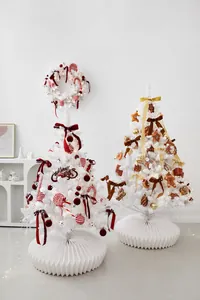 Detail of elegant white Christmas trees with red bows and gold ornaments on pleated bases