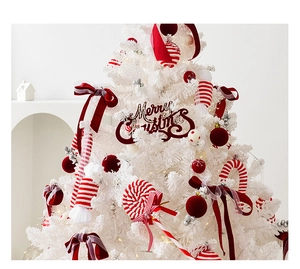 Close-up of red bows and candy cane ornaments on a luxury white Christmas tree