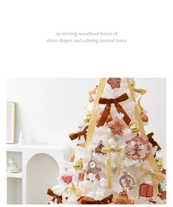 Close-up of white Christmas tree decorated with gold bows and gingerbread ornaments