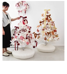 Detail of white artificial Christmas trees with festive bows and honeycomb base