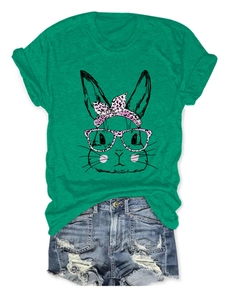 Detailed flat lay of green cotton rabbit print t-shirt with blue ripped denim shorts