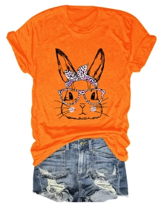 Flat lay of women's orange bunny print t-shirt and distressed denim shorts summer set