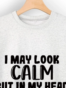 Close-up of crew neck sweatshirt featuring I MAY LOOK CALM BUT text print