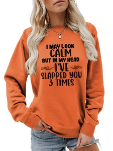 Detail of orange sweatshirt ribbed collar and black humor quote print on the chest