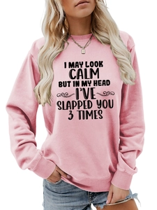 Detail of pink long-sleeve sweatshirt with humor text and ribbed cuffs on model