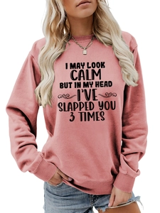 Detail of pink crewneck sweatshirt with 'I May Look Calm But' slogan and rib cuffs