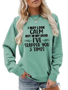Detailed view of mint green sweatshirt with 'I May Look Calm' humorous print