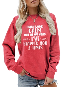 Detail of red crewneck sweatshirt featuring white humorous slogan print and ribbed cuffs