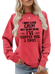 Close-up of red crewneck sweatshirt featuring black humor text print on the chest fabric