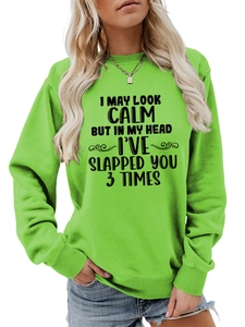 Detail of bright green crewneck sweatshirt featuring black slogan typography and soft cotton texture
