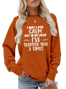 Detail of the white slogan print on a burnt orange crewneck sweatshirt for women